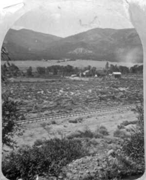 This July, 1881, view of the rear of the Hutchinson Ranch was the right half of a stereopticon card. The view is south from the mesa (today's County Road 120), with Methodist and Poncha mountains in the background. The narrow-gauge line from Salida to Poncha Springs and Gunnison is so new that the ties have no ballast. Note the rail fences and corrals, and that land which is now irrigated pasture was then covered in sagebrush.