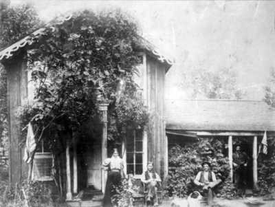 July 4, 1895, at the ranch house. Left to right, Annabelle McPherson Hutchinson and sons Joseph Mills Hutchinson, Bailey Forbes Hutchinson, and John Arthur Hutchinson. A fourth son, Harold Charles Hutchinson, was not present. Note the family dog resting at the foot of Bailey.