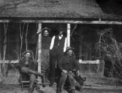 On the homestead porch are, left to right, John Arthur (Art) Hutchinson, Harold Charles Hutchinson, Joseph Mills Hutchinson, and Bailey Forbes Hutchinson.