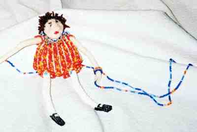 One of Jane Rhett's 'Bag Hags' -- beaded dolls that serve as necklaces and storage. The head tilts back to open the bag.