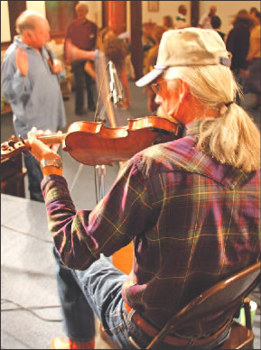 Fiddler Dennis Fisher provides the tunes while Randy Barnes helps keep the beat at a recent dance in Leadville.