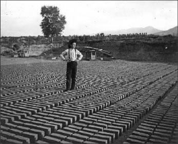Figure 1. This photograph is published In Eleanor Fry’s Salida: The Early Years. There, the caption reads “Clay was packed into three-brick molds which were then dumped on the ground in long rows to sun dry. This unidentified boy may have been responsible for [turning] the thousands of bricks drying.”