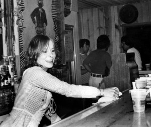  Judy Burney serves a customer at Uncle Dick’s, a popular 3.2 bar from 1977 to 1981. Photo courtesy of Dvora Kanegis. Bottom, The sign for the old East West Club marked the party place in Smeltertown. Photo courtesy of Dick Mansheim.