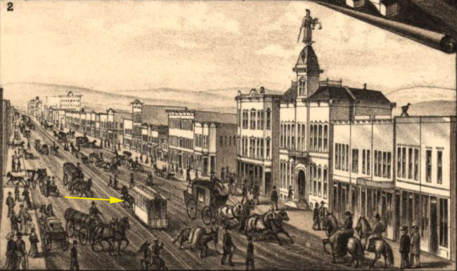 The yellow arrow points to a horse-drawn trolley riding the rails on Leadville’s Harrison Street in 1882.